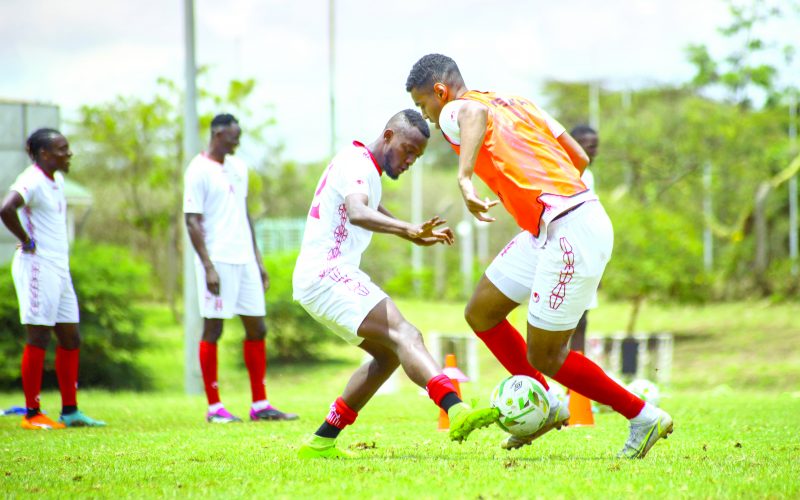 Daniel Anyembe (right) dribbles the ball past Hassan Omar during a Harambee Stars’ training session. PHOTO/David Ndolo