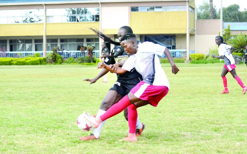 Mohammed Shabah of Makolanders (left) vies for the ball against Zeinab Khamis of Kibera Girls Soccer Academy during their WPL held at Stima Club grounds. PHOTO/Rodgers Ndegwa