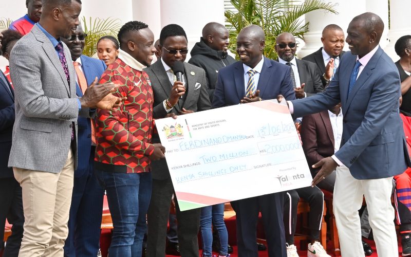 Ferdinand Omanyala receives cheque from President Willliam Ruto. PHOTO/Statehouse (@StateHouseKenya)/Twitter