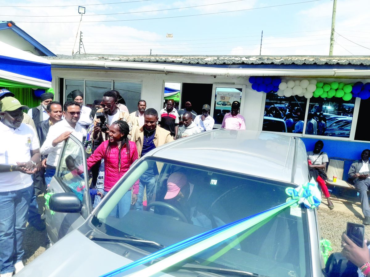 Double World Record holder Faith Kipyegon (left) with the car she bought her father as a gift at the weekend.