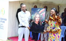 Joseph Kamau (Sinai),  a graduate of Makerere University presents a painting to Pastor Dorcas Rigathi at Kiandutu slum in Thika on Friday. PHOTO/OSPD