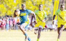 KCB rugby player, Elphas Adunga running past Kabras players during the TISAP 7’s in Eldoret. PHOTO/Lucky Oluoch