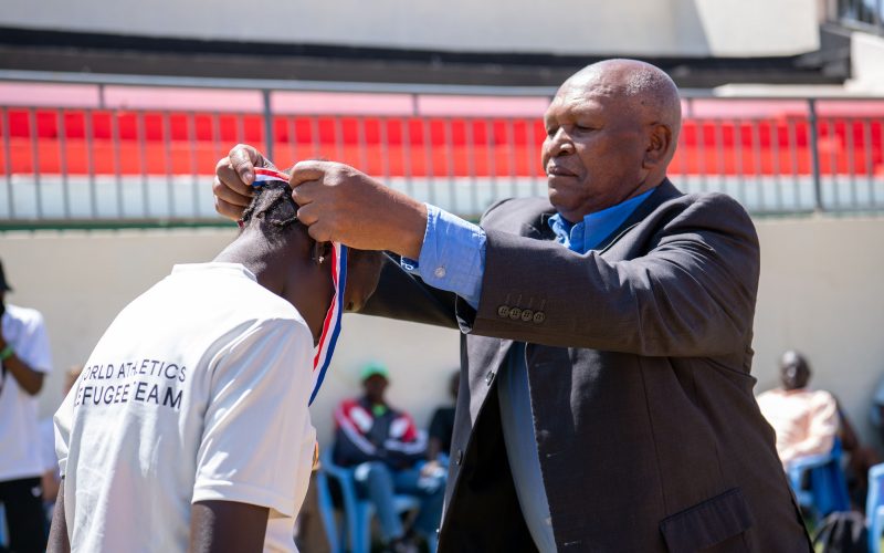 Kip Keino presents an Athlete Refugee Team athlete with their medal . PHOTO/UNHCR