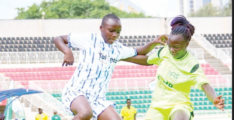 Busia’s Diana Anyango (White) battles Kakamega’s Dalphine Ayega (Green) in girls U19 during the opening of Talanta Hela Soccer finals at Nyayo Stadium. PHOTO/David Ndolo