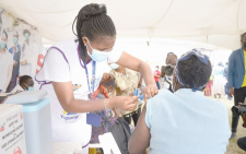 A healthcare worker administers Pfizer Covid-19 vaccine to a woman during a mass vaccination in February 2022. PHOTO/Print