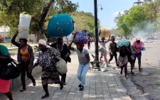People run through the streets of Port-au-Prince as bullets fly.