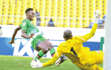 Harambee Stars’ Duke Abuya (left) scores against Burundi national team’s goalkeeper during their World Cup qualifier on Friday.