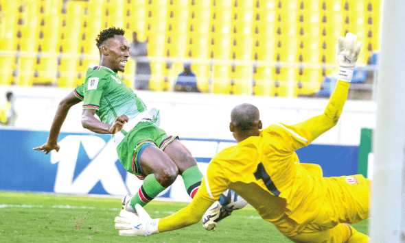 Harambee Stars’ Duke Abuya (left) scores against Burundi national team’s goalkeeper during their World Cup qualifier on Friday.