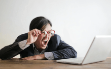 Man using his laptop seeming frustrated. PHOTO/Pexels