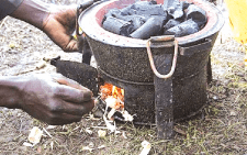 A man lighting a charcoal jiko. PHOTO/Print