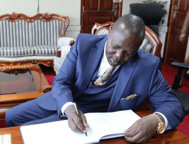 Kisumu Senator Tom Ojienda signing a visitor's book while meeting with former CS Zachariah Njeru. PHOTO/@CS_Njeru/X