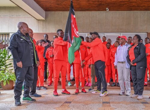 CS Kipchumba Murkomen handing over the Kenyan flag to Under-20 athletics team. PHOTO/@kipmurkomen/X