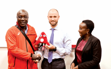 France Ambassador of Sports Samuel Ducroquet gifts Kenya’s head of delegation at the Paris Paralympics, Sports Administrative Secretary Evans Achoki (left) as Kenya’s ambassador to France, Betty Cherwon looks. PHOTO/James Waindi