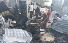 A woman trys to salvage her burnt sufurias to sell them to scrap metal dealers. PHOTO /Christine Musa