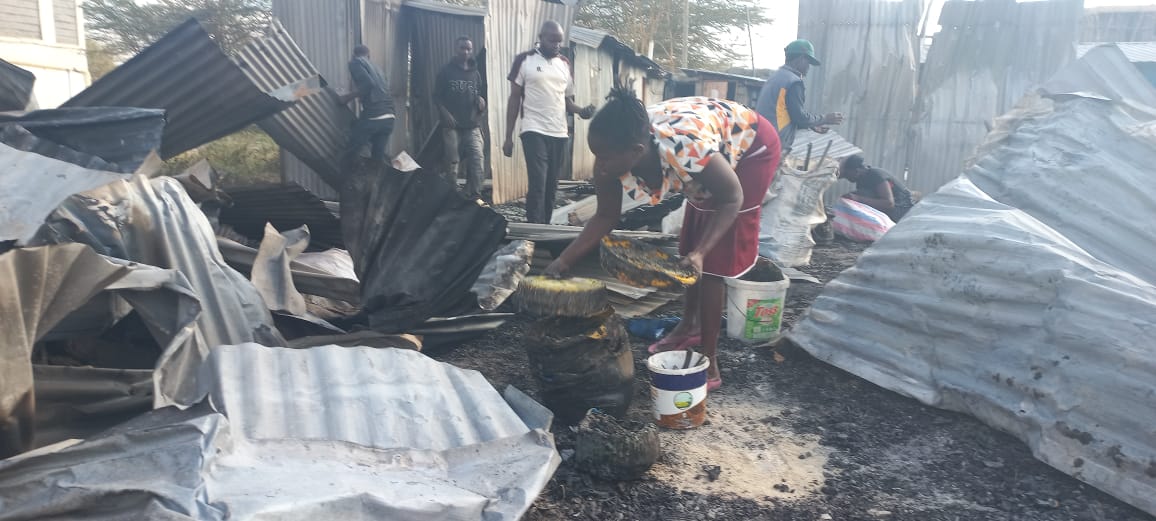 A woman trys to salvage her burnt sufurias to sell them to scrap metal dealers. PHOTO /Christine Musa