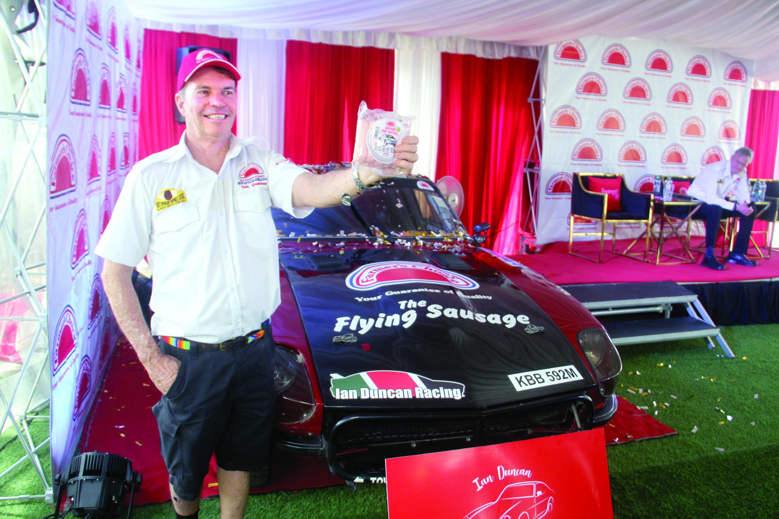 Veteran Rally Driver Ian Duncan holds a packet of Sausage at Farmers Choice headquarters after the company backed him in the 2023 EASC Rally. PHOTO/Philip Kamayka