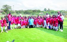 John Bob Oyugi (in blue) poses with a local team. PHOTO/Print