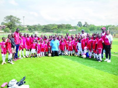 John Bob Oyugi (in blue) poses with a local team. PHOTO/Print