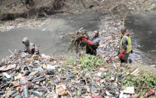 Young people clean up a section of the Nairobi River at the Michuki  Memorial Park in Nairobi on August 21, 2023 in a programme funded by the national government and UNEP.