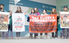 Young climate activists at COP29 hold banners demanding $5 trillion per year in climate finance, calling on elites and corporations to fulfill their climate obligations and support vulnerable nations. PHOTO/Print