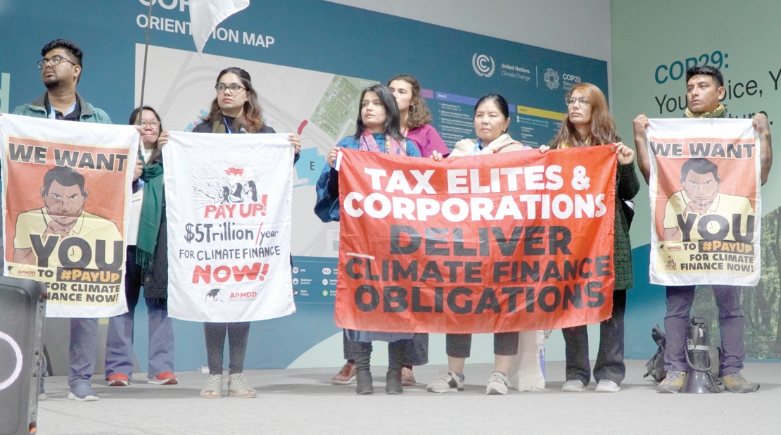 Young climate activists at COP29 hold banners demanding $5 trillion per year in climate finance, calling on elites and corporations to fulfill their climate obligations and support vulnerable nations. PHOTO/Print