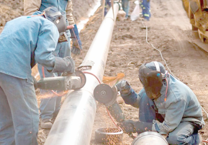 Workers weld a pipeline equipment. PHOTO/Print