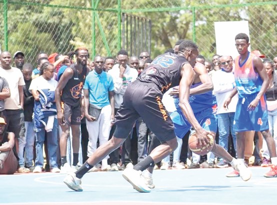 Two Umoja basketball team players ( in blue jersey) prepare to counter Thunder player Taylor Ongwae (with ball) during a past men’s premier league game in Eldoret City. PHOTO/KNBL