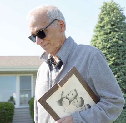 John Prevost, a brother of Pope Leo XIV, holding a portrait of him and his two brothers from 1958 outside his home in New Lenox, Ill, on Thursday. John J Kim. PHOTO/Chicago Tribune, via Associated Press
