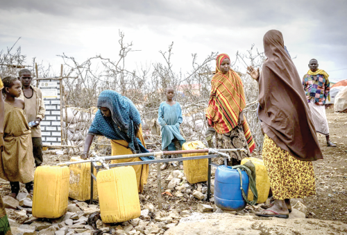 Somalians fill water bottles in a displacement camp in Baidoa for drought victims. PHOTO/Print