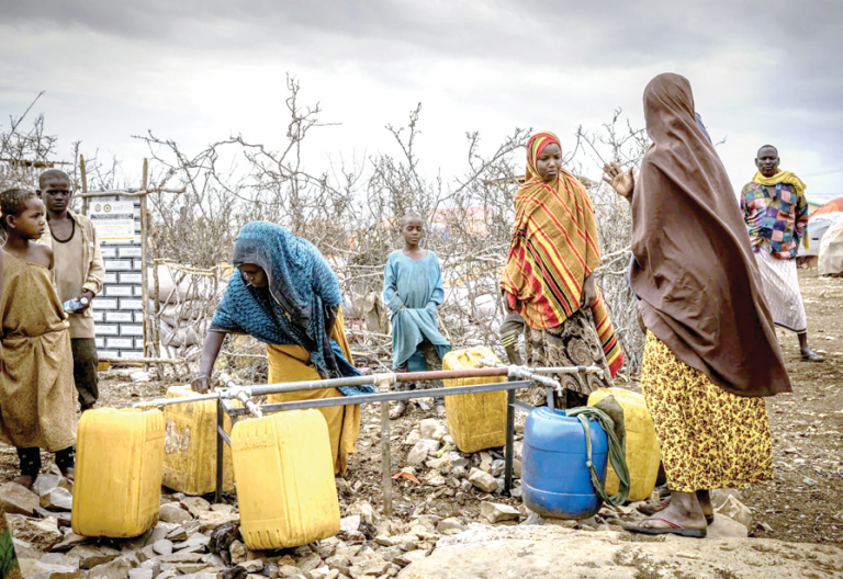 Somalians fill water bottles in a displacement camp in Baidoa for drought victims. PHOTO/Print