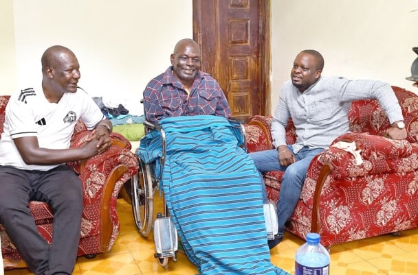 SJAK president James Waindi (right) with veteran coach Robert Matano have a chat with ailing Tom Olaba (centre) at his house in Nkoroi, Ongata Rongai. PHOTO/SPORTPICHA