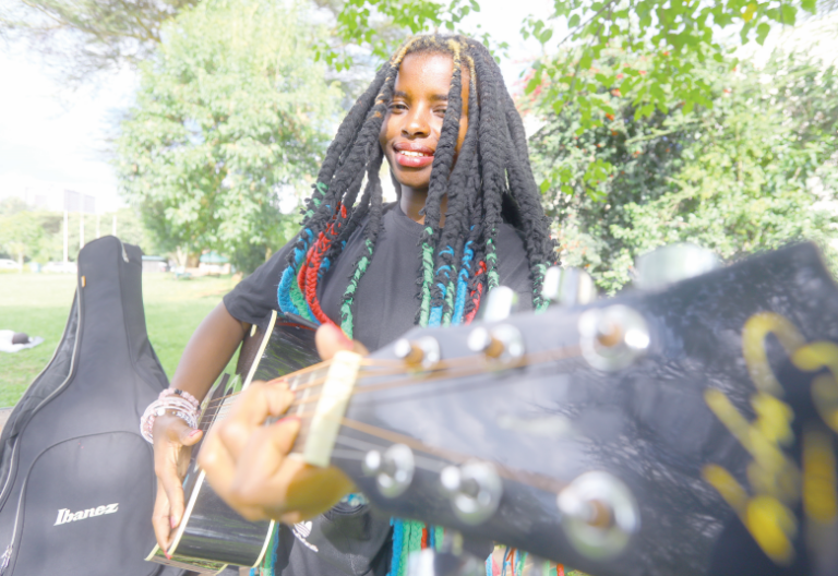 Twenty-year-old Truphena Muthoni plays her guitar at Nairobi’s Michuki Memorial park yesterday. PHOTO/Philip Kamakya