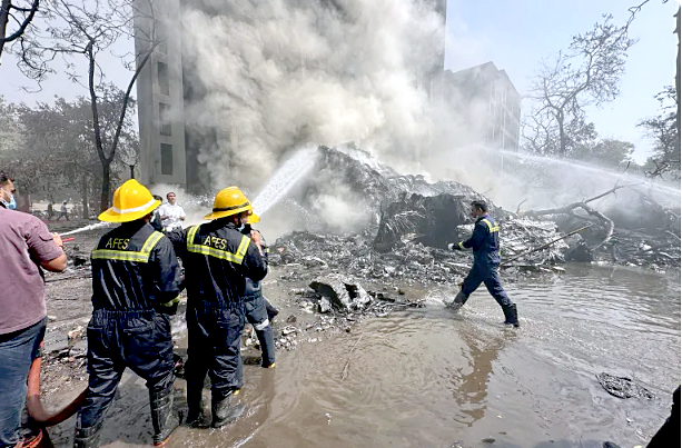 Rescue team members work as smoke rises at the site where an Air India plane crashed in Ahmedabad, India, on June 12, 2025. PHOTO/Print