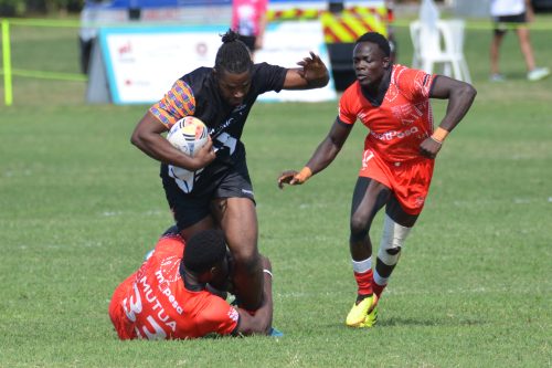 Kenya’s Mutua goes low on a Ghanaian opponent as Javan keeps a close watch during their dominant 33-0 victory. PHOTO/@KenyaSevens/X