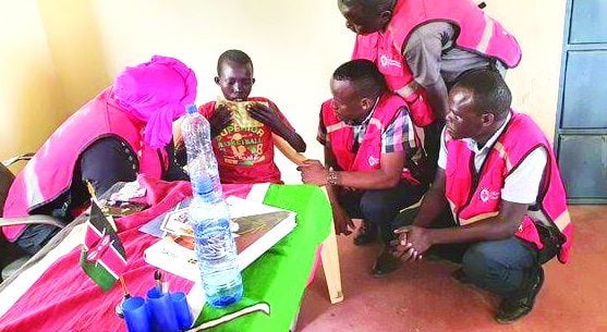 Kenya Red Cross Society staff with the Grade Seven pupil who was abducted in Yatia village, Baringo North, was in Silale downhills. PHOTO/ KRCS