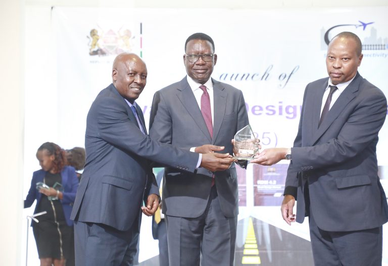Transport Cabinet Secretary Davis Chirchir (centre) with Roads Principal Secretary Joseph Mbugua (left) hand a plaque to Kenya National Highways Authority (KeNHA) Director General Kung’u Ndung’u during the launch of Kenya Road Design Manuals and Specifications 2025 on June 9, 2025. PHOTO/Samuel Kariuki