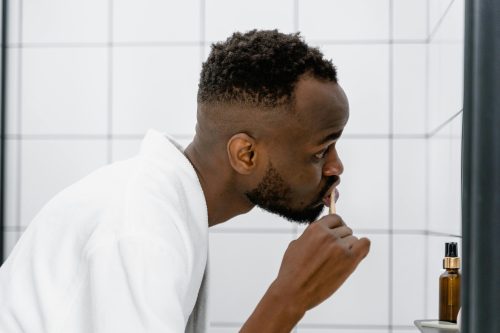 A man in white robe brushing his teeth. Image used for representational purposes only. PHOTO/Pexels