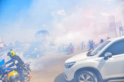People flee as teargas is fired during a disrupted opposition meeting in Gilgil. PHOTO/@methumuhia/X