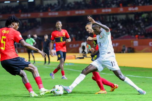 Harambee Stars’ Boniface Muchiri battles for possession against Angola players during the CHAN Group A clash. PHOTO/@KasaraniStadium/X