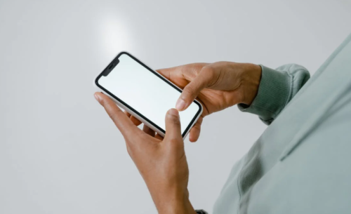 Image of a person holding a phone with a blank screen used for representation only. PHOTO/Pexels