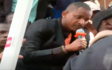 Babu Owino climbs the perimeter wall to address mourners