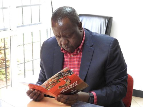 Fred Matiang'i holding Jubilee Party book. Photo/