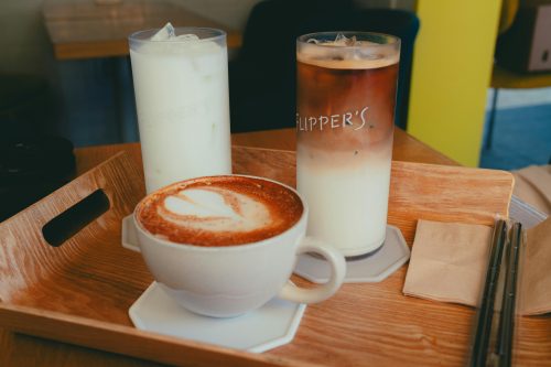 Coffee drinks including an iced latte, iced milk, and cappuccino served on a wooden tray. Photo used for illustration. PHOTO/Pexels