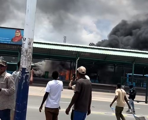 Youths watch as a tram bus is set on fire in Tanzania during the ongoing protests. PHOTO/Screengrab by K24 Digital of TikTok video by @commonbuzzard26
