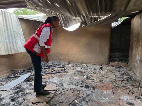A Kenya Red Cross officer inspects the remains of a house destroyed in the Angata Barikkoi clashes. PHOTO/@KenyaRedCross/X