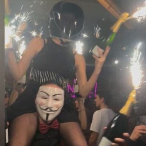 People wearing protective masks hold champagne bottles inside the crowded Le Constellation bar in Crans-Montana, Switzerland. PHOTO/@TonyTruant01/X