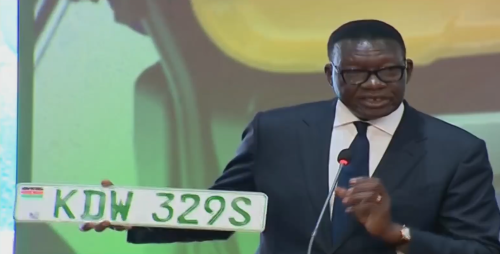 Davis Chirchir holds a green electric vehicle number plate during the launch of Kenya’s National e-Mobility Policy. PHOTO/Screengrab by People Daily Digital/Citizen TV