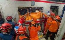 Train collision in Indonesia kills 14 as rescuers work to reach survivors