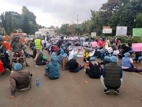 Healthcare workers sitting down along Embu-Meru road, meters from Embu Level 5 hospital. PHOTO/https://web.facebook.com/LennyMaxwellKivuti