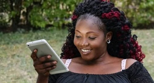 The late Sharon Otieno smiling while scrolling on her smartphone. PHOTO/@omwambaKE/X